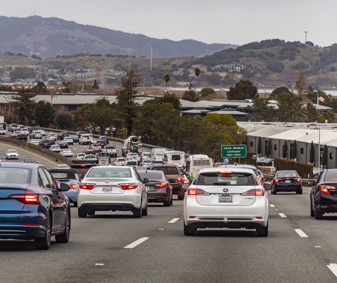 Slow traffic on a California freeway with hills behind