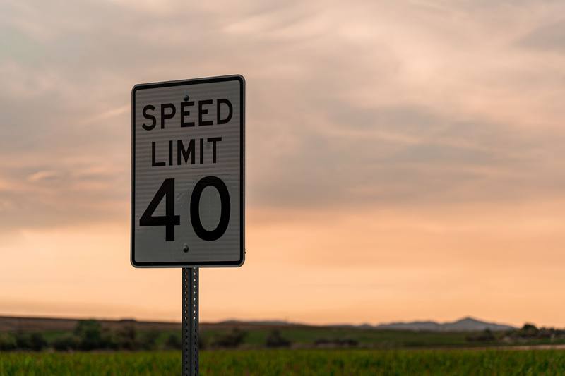 A speed limit sign against an evening sky